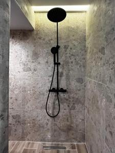 a shower in a bathroom with a shower head at Orfeas Luxury Rooms & Studio in Skopelos Town