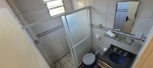 a small bathroom with a toilet and a mirror at Residencial Santa Maria in Laguna