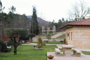 a park with benches and a building and a cemetery at Outeiro do Moinho in Campo do Gerês