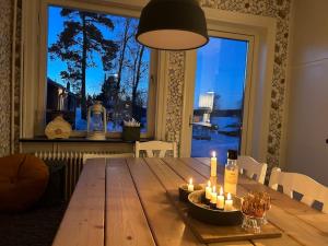 a dining room table with candles and a large window at Edänge 61 in Ljusdal
