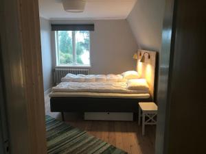 a small bedroom with a bed with a window at Edänge 61 in Ljusdal