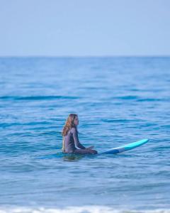 拉巴特的住宿－Studio prestige N1 pieds sur Mer，坐在海洋冲浪板上的年轻女孩