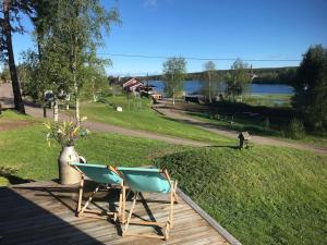 two chairs on a deck with a view of a lake at Edänge 61 in Ljusdal