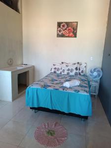 - une chambre avec un lit et une couette bleue dans l'établissement Casa BRISA DO MAR Abaís, à Praia Da Caueira