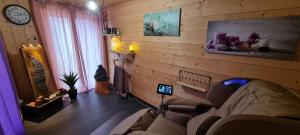 - un salon avec un canapé et un réveil sur le mur dans l'établissement Maison d'hôtes et SPA La Boucotte, à Vellerot-lès-Vercel