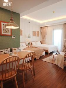 1 dormitorio con 1 cama, mesa y sillas en FLC SEATOWN QUY NHƠN, en Quy Nhon
