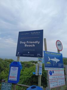 um sinal para uma praia que aceita cães na praia em Wave Echo em Plettenberg Bay