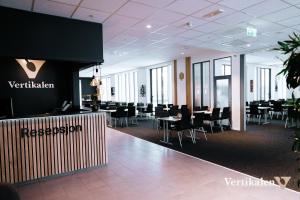 une salle de conférence avec des tables et des chaises dans un bâtiment dans l'établissement Vertikalen, à Lillesand