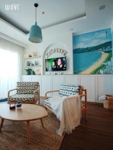 sala de estar con 2 sillas y mesa en FLC SEATOWN QUY NHƠN, en Quy Nhon
