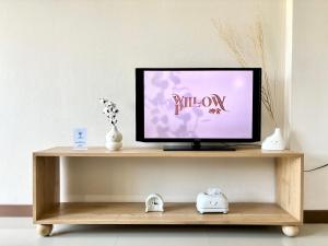 a television sitting on a wooden shelf in a room at Willow Pillow Guest House & Poshtel in Chumphon