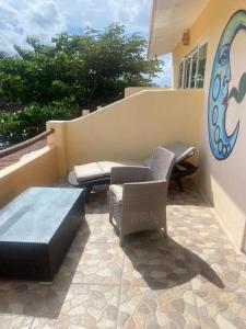 un patio con sillas, un banco y una mesa en Hidden Jems Mahahual Hotel & Hostel en Mahahual