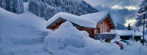 una cabaña de madera cubierta de nieve con una boca de incendios en 9-Bed Chalet with Easy Access to Avoriaz 1800, en Morzine