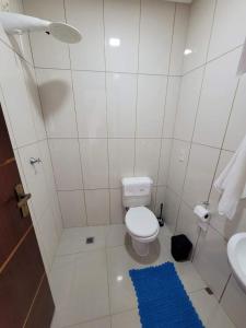 uma casa de banho com um WC e um tapete azul em Lindo sobrado a beira rio em Piçarras