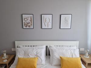 維洛納的住宿－MARCO POLO APARTMENT，卧室配有一张白色床,墙上挂有4张照片