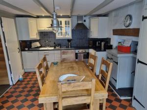 a kitchen with a wooden table and chairs at Cilrhiw, Seaside Stone Cottage in Llangrannog in Llangrannog