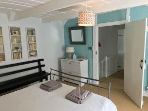 um quarto com uma cama e um lustre em Cilrhiw, Seaside Stone Cottage in Llangrannog em Llangrannog