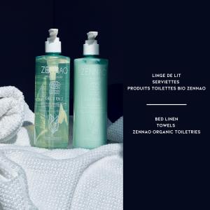 due bottiglie di shampoo sedute sopra asciugamani bianchi di Villa A LICCIA a Figari