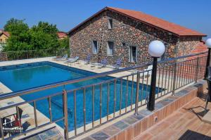 a swimming pool on a balcony with a fence at Hôtel les truites in Imouzzer du Kandar
