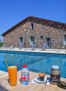 uma mesa com bebidas junto a uma piscina em Hôtel les truites em Imouzzer Kandar
