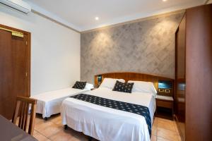 A bed or beds in a room at Hotel Agostini