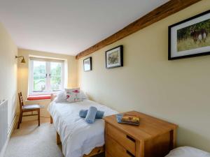 a bedroom with a bed and a table and a window at 3 Bed in Isle of Purbeck IC027 in Kingston