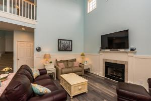 a living room with a couch and a fireplace at Fishful Thinking Canal front with boat dock Ocean Views kayak and paddle board in Ocean Isle Beach