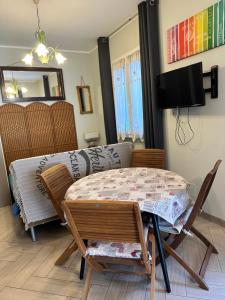 a room with a table and chairs and a television at Casa del sasso in Bergeggi