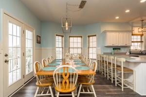 a dining room with a long table and chairs at Fishful Thinking Canal front with boat dock Ocean Views kayak and paddle board in Ocean Isle Beach