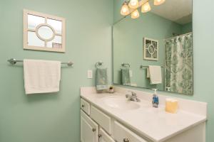 a bathroom with a sink and a mirror at Fishful Thinking Canal front with boat dock Ocean Views kayak and paddle board in Ocean Isle Beach +56 photos