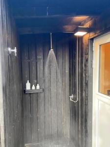 a shower in a bathroom with a wooden wall at Audkula Dome Cabin in Hella