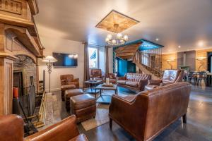 a living room with leather furniture and a fireplace at KasaLilou, Grand Gîte de prestige St Lary in Vignec