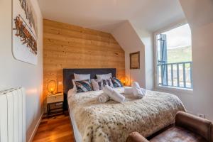 a bedroom with a large bed with a wooden wall at KasaLilou, Grand Gîte de prestige St Lary in Vignec