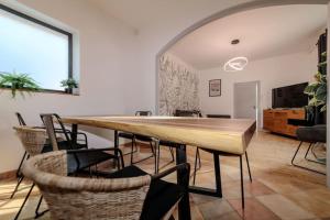 une salle à manger avec une grande table et des chaises en bois dans l'établissement VILLE ET VOLCANS - Maison 9 couchages avec garage et extérieur, à Clermont-Ferrand