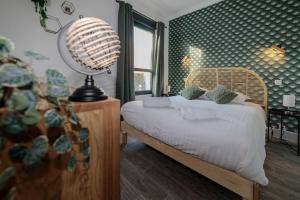 a bedroom with a bed and a lamp in it at VILLE ET VOLCANS - Maison 9 couchages avec garage et extérieur in Clermont-Ferrand