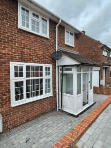 a brick house with white windows and a door at Beautiful 3-Bed House in Romford in Romford