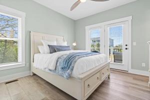 a white bedroom with a bed and two windows at Havana in Ocean Isle Beach +82 photos