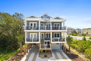 a large white house with balconies and trees at Havana in Ocean Isle Beach