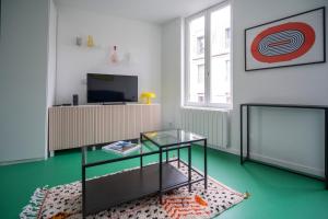 a living room with a glass table and a television at Studio - Alma in Le Havre