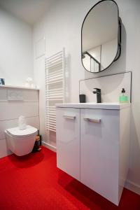 a white bathroom with a toilet and a mirror at Studio - Alma in Le Havre