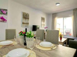 un comedor con una mesa con platos y copas de vino en 2 bedrooms appartement with shared pool and wifi at Fuengirola en Fuengirola