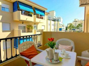 una mesa blanca y sillas en un balcón con un edificio en 2 bedrooms appartement with shared pool and wifi at Fuengirola en Fuengirola