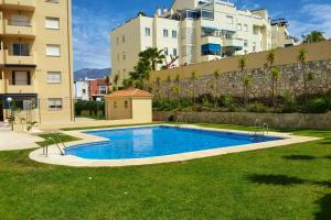 una piscina en un patio frente a algunos edificios en 2 bedrooms appartement with shared pool and wifi at Fuengirola en Fuengirola