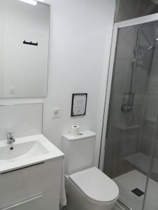 een witte badkamer met een toilet en een douche bij El Merendero in Utrera