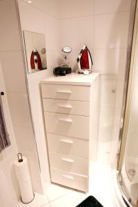 een badkamer met witte laden en een douche bij Home In Birmingham New Street in Birmingham