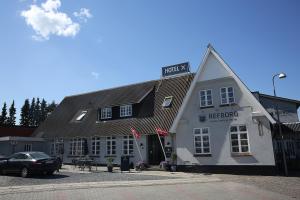 een zwarte auto geparkeerd voor een wit gebouw bij Refborg Hotel in Billund