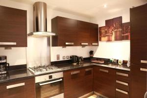 una cucina con armadi in legno e piano cottura. di Home In Birmingham New Street a Birmingham