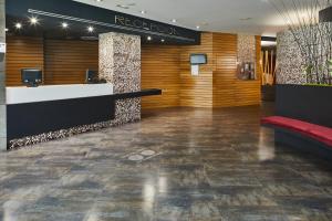 a lobby of a hotel with a red bench at Silken Gran Teatro in Burgos