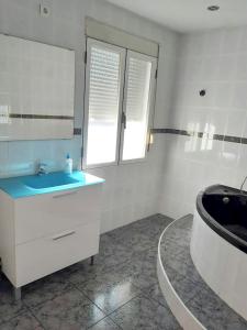 a bathroom with a sink and a tub and a mirror at 2 bedrooms apartement with wifi at Barbastro in Barbastro