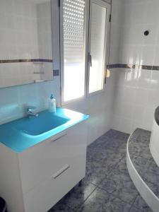 a bathroom with a blue sink and a window at 2 bedrooms apartement with wifi at Barbastro in Barbastro