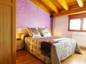 1 dormitorio con 1 cama con pared morada en 2 bedrooms appartement with wifi at Tubilla del Lago, en Tubilla del Lago